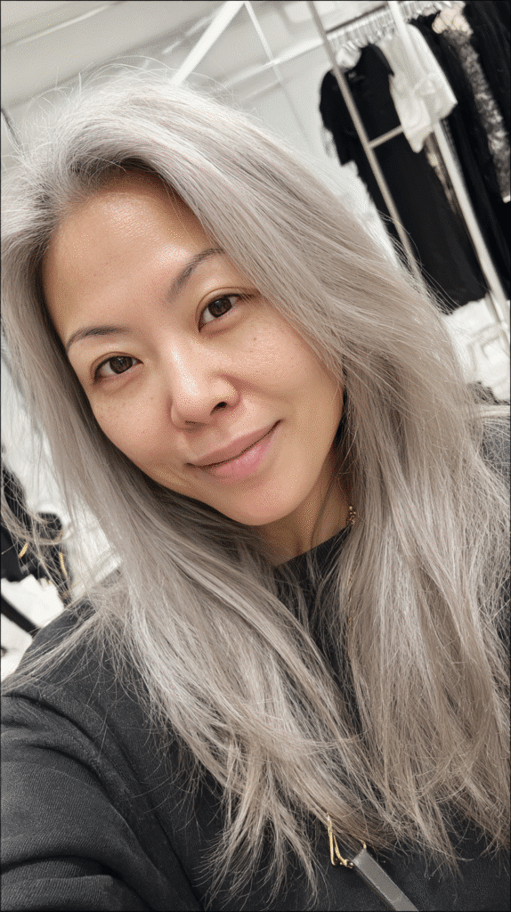 Woman with frosted grey blonde highlights in shoulder-length hair.