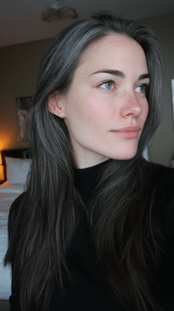 Long straight hair enhanced with delicate strands of grey frosting for a soft sheen.