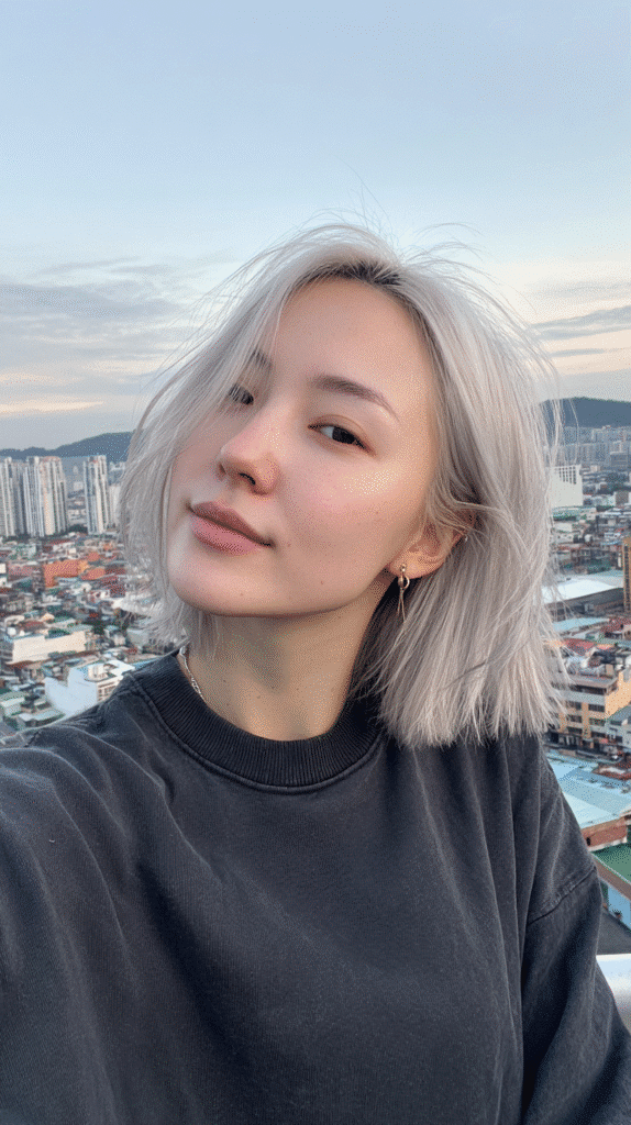 Woman with an icy grey blonde bob cut at chin length.