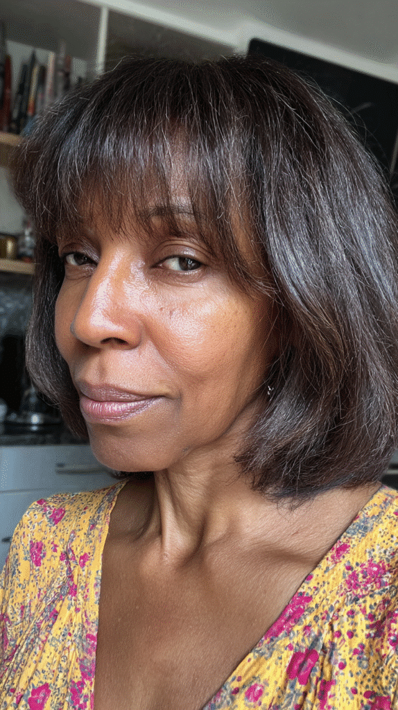 Woman with a layered bob and wispy bangs, enhancing texture and fullness.
