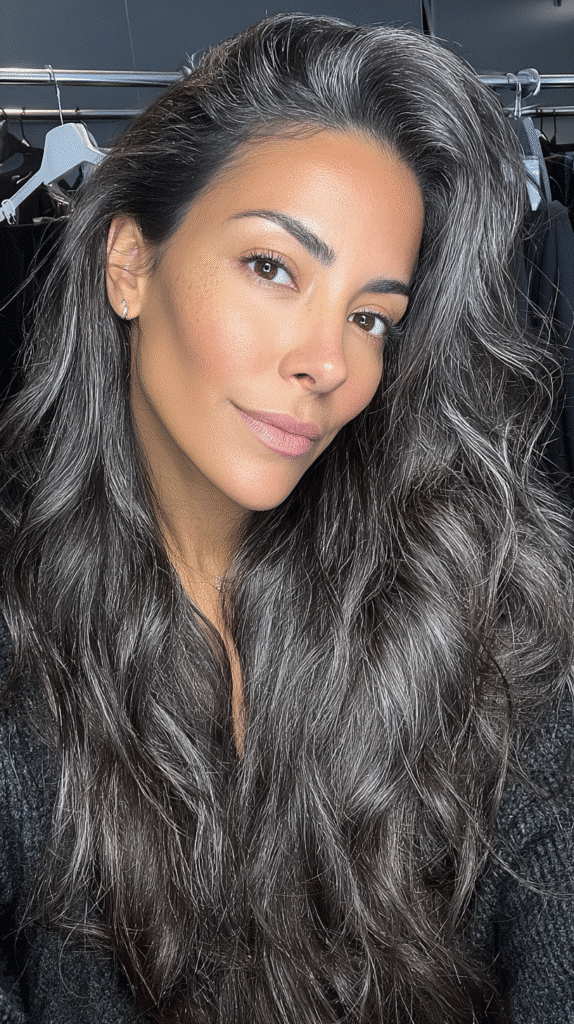 Thick, voluminous dark hair styled with eye-catching metallic grey highlights.