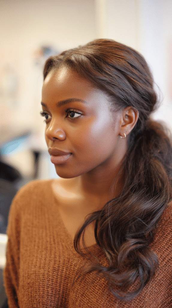 African-American woman with a sleek side ponytail and baby hairs styled into swoops.