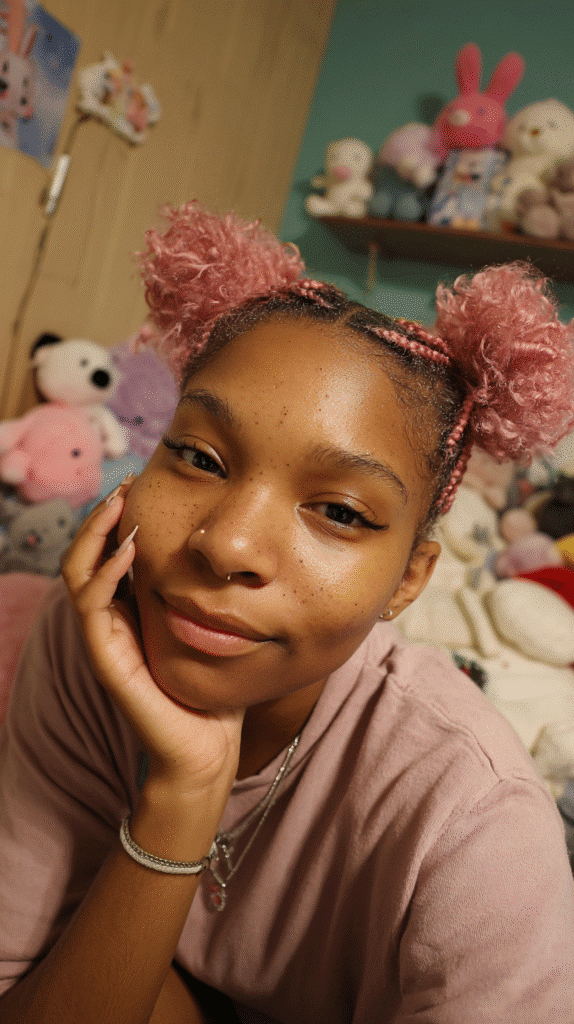 Young woman with soft pink pigtail puffs styled naturally with playful energy.