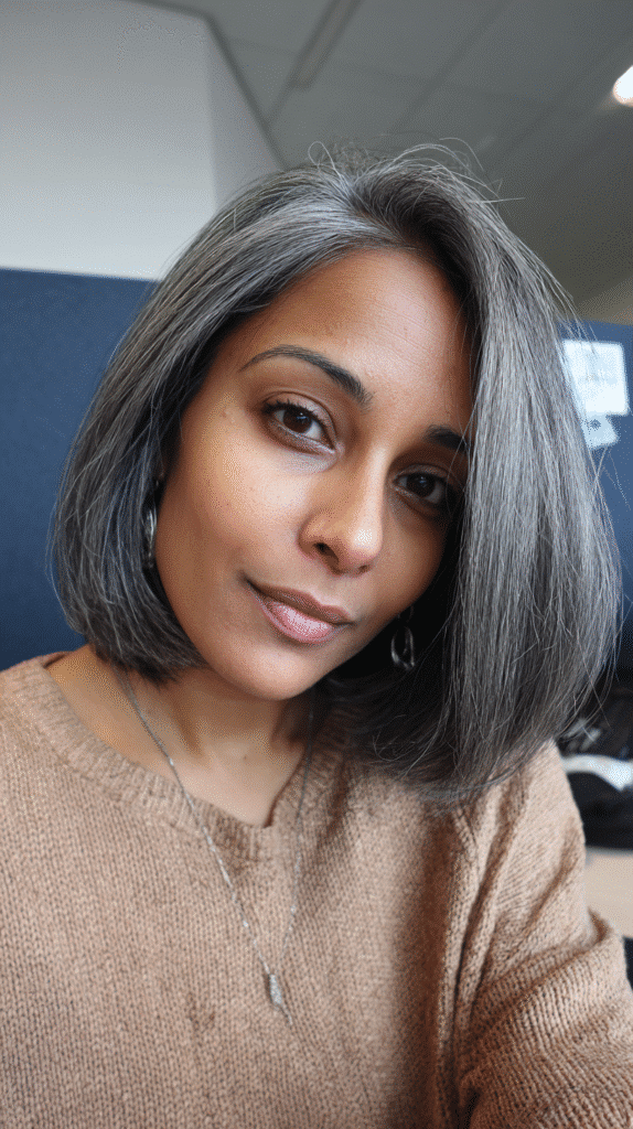 A sleek blunt bob haircut accented with sharp steel grey highlights for contrast.